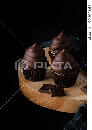 Chocolate cupcakes on wooden cutting board Chocolate cupcakes on wooden cutting board 49469867