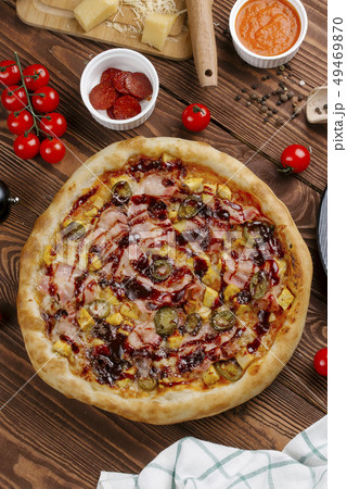 Pizza and ingredients on wooden table 49469870