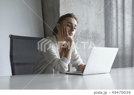 Bored businesswoman working on laptop 49470039
