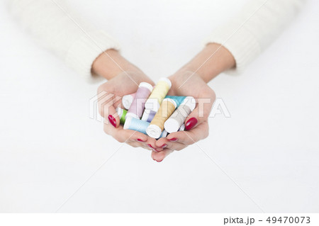 Hands of woman holding spools of cotton 49470073