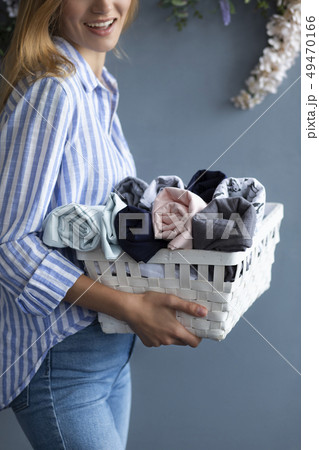 Woman carrying basket of fabrics 49470166