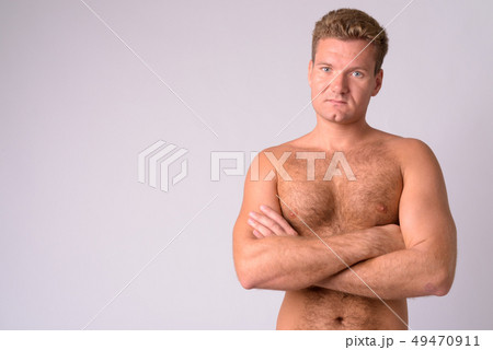 Portrait of young blonde shirtless man with chest hair crossing arms Portrait of young blonde shirtless man with chest hair crossing arms 49470911