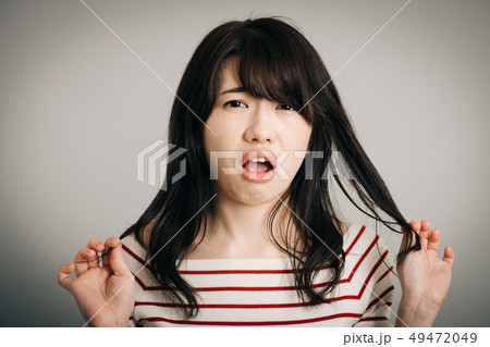ヘアスタイルが気に入らない若い日本人女性の写真素材
