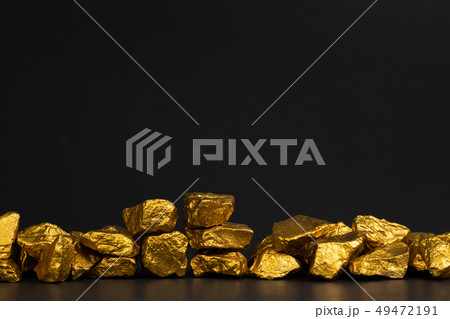 A pile of gold nuggets or gold ore on black A pile of gold nuggets or gold ore on black 49472191