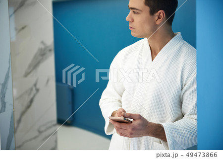 Young man with smartphone in spa center Young man with smartphone in spa center 49473866
