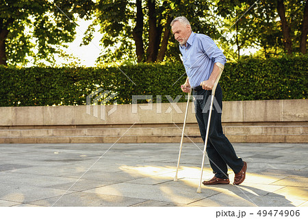 Man Strolls in Park with Crutches. Man at Therapy. 49474906