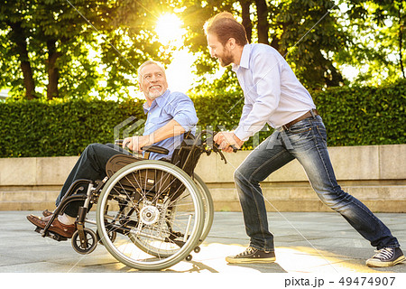 Son and Old Man Have Fun. Disabled in Wheelchair. 49474907