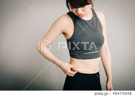 お腹のぜい肉をつまむ若い日本人女性　ダイエットイメージ 49475048