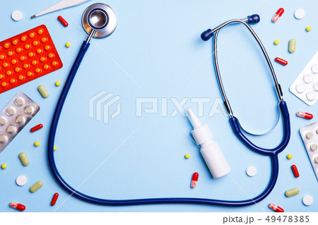 Cold medicine, thermometer and phonendoscope on a blue background. 49478385