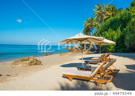 Pair of deck chairs at tropical beach 49479349