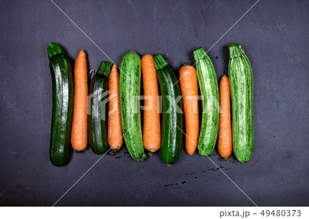 Fresh organic wet carrots and zucchini on black Fresh organic wet carrots and zucchini on black 49480373