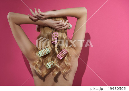 Sensual blonde lady with colorful rollers in locks Sensual blonde lady with colorful rollers in locks 49480506