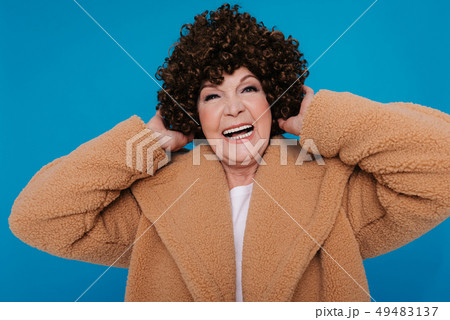 Portrait of cheerful elderly woman with dark curly hair wearing casual clothes 49483137