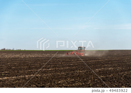Tractor plowing fields. 49483922