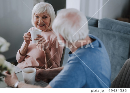 Positive elder couple drinking tea on sofa 49484586