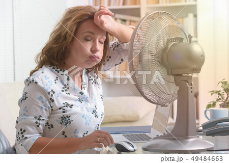 Woman suffers from heat in the office or at home 49484663