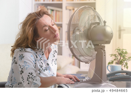 Woman suffers from heat in the office or at home 49484665