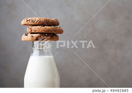 Bottle with milk and chocolate chip cookies. Bottle with milk and chocolate chip cookies. 49492885