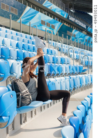 young girl sitting on the seat in the stadium. 49493011
