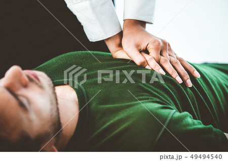 Rescuer hands doing CPR on heart attacked man. 49494540