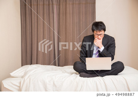 ベッドでPCを見る男性（考える） 49498887