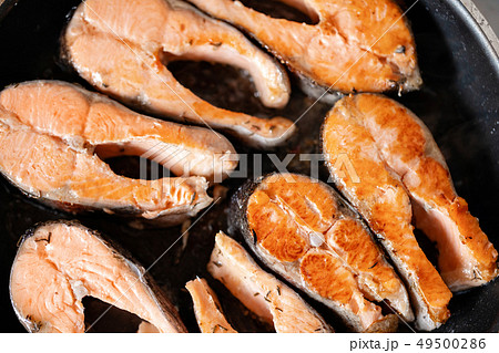 Close-up of roasted salmon steaks in a frying pan, top view. Fresh seafood for frying. Close-up of roasted salmon steaks in a frying pan, top view. Fresh seafood for frying. 49500286