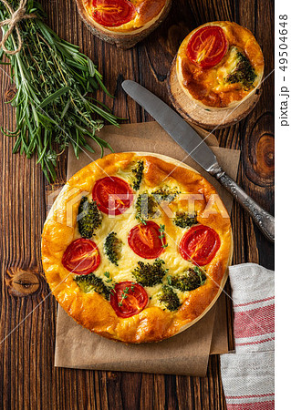 Vegetable pie with broccoli, peas, thyme. tomatoes and cheese on wooden background. Copy space. Vegetable pie with broccoli, peas, thyme. tomatoes and cheese on wooden background. Copy space. 49504648