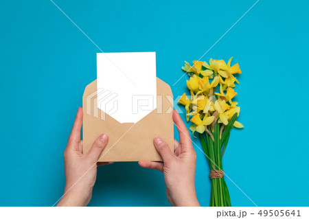 female hands holding craft envelope with a card, 49505641