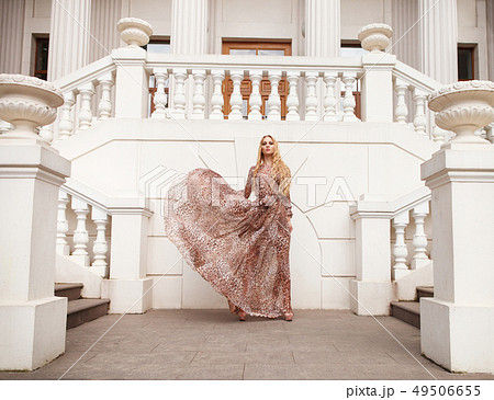 Beautiful blond woman in long dress outdoors Beautiful blond woman in long dress outdoors 49506655