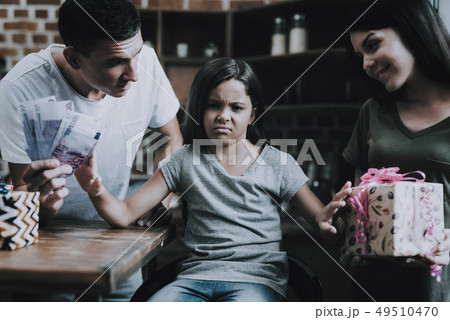Parents want Buy Love. Sad Girl Sit at Table. Parents want Buy Love. Sad Girl Sit at Table. 49510470