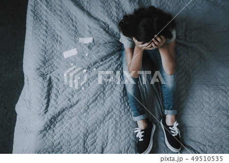 Girl Sit on Gray Bed. Child Hands Clasped on Head. 49510535