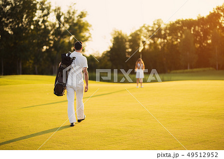 Golfer Walks by Course Family Recreation. 49512952