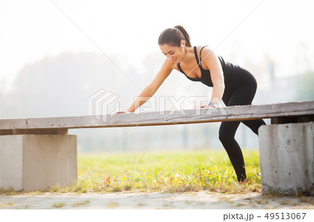 Portrait of beautiful sporty woman 20s in sportswear doing push-ups, and listening to music with Portrait of beautiful sporty woman 20s in sportswear doing push-ups, and listening to music with 49513067