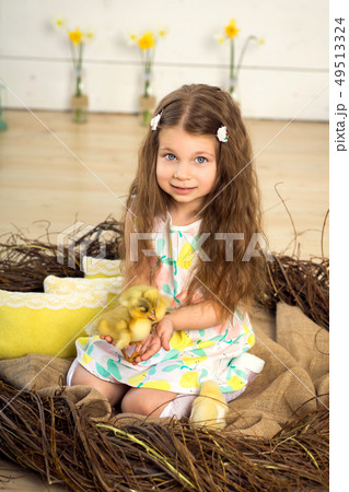 happy little girl in a dress sits in a nest and happy little girl in a dress sits in a nest and 49513324
