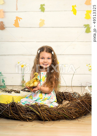 happy little girl in a dress sits in a nest and 49513325