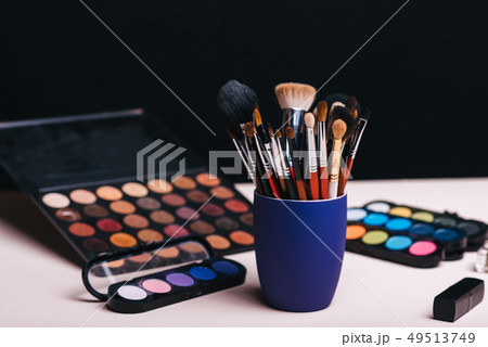 set of makeup brushes on the background of color eye shadow palette 49513749