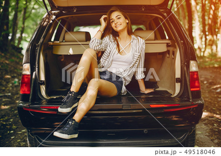Girl in a summer park near car 49518046