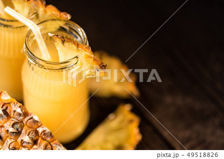 Pineapple juice and slice placed on a wooden table 49518826