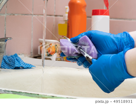 The girl washes the knife with a kitchen sponge The girl washes the knife with a kitchen sponge 49518931