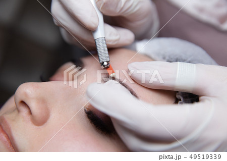 Permanent Makeup For Eyebrows. Microblading brow. Beautician Doing Eyebrow Tattooing For Female Face Permanent Makeup For Eyebrows. Microblading brow. Beautician Doing Eyebrow Tattooing For Female Face 49519339