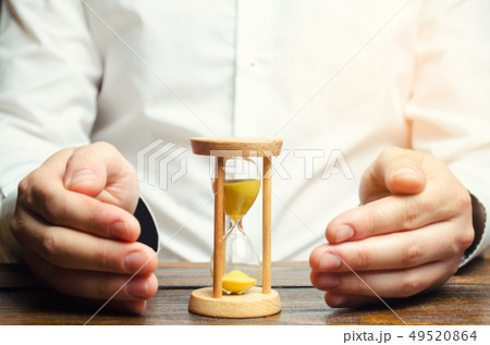 Man protects the hourglass. Concept of saving time 49520864