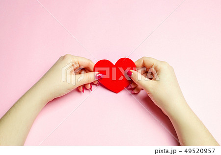 The girl holds a red heart in hands. 49520957