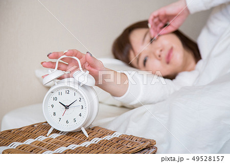 目覚まし時計で起きる女性(時計にピント) 目覚まし時計で起きる女性(時計にピント) 49528157
