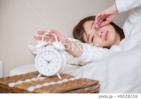 目覚まし時計で起きる女性(女性にピント) 目覚まし時計で起きる女性(女性にピント) 49528159