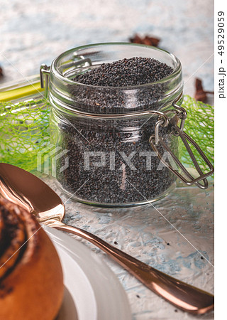 Glass jar with sealed cover full of raw poppy 49529059