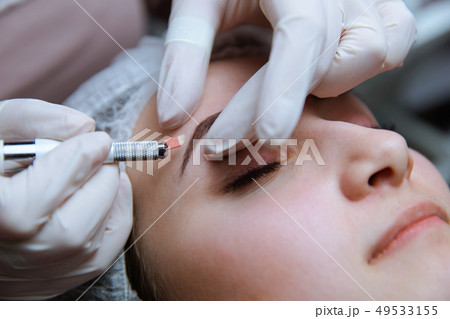 Permanent Makeup For Eyebrows. Microblading brow. Beautician Doing Eyebrow Tattooing For Female Face 49533155