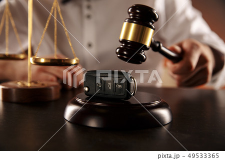 Close up of judge gavel and car keys over soundboard on white Close up of judge gavel and car keys over soundboard on white 49533365