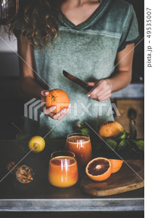 Woman making fresh blood orange juice or smoothie Woman making fresh blood orange juice or smoothie 49535007