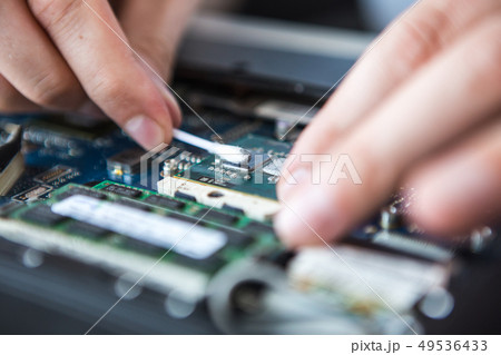 Man examines laptop PC clean thermal paste 49536433