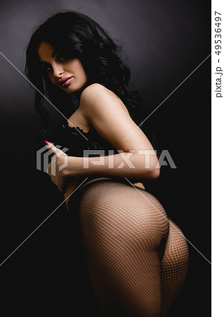 Sexy woman in lace black sensual lingerie and pantyhose with long hair posing in studio. 49536497